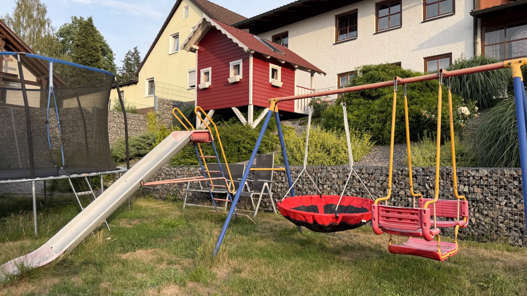 Garten mit Schaukel, Rutsche und Trampolin